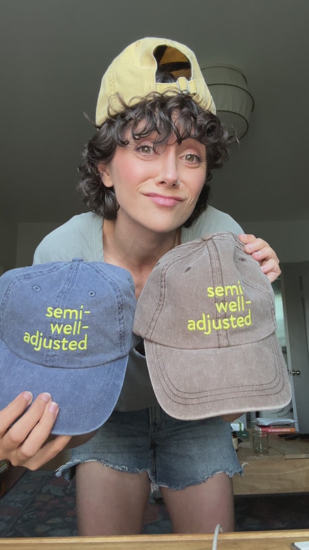 Alyson wears one hat and holds two others to show off the different colors and designs.